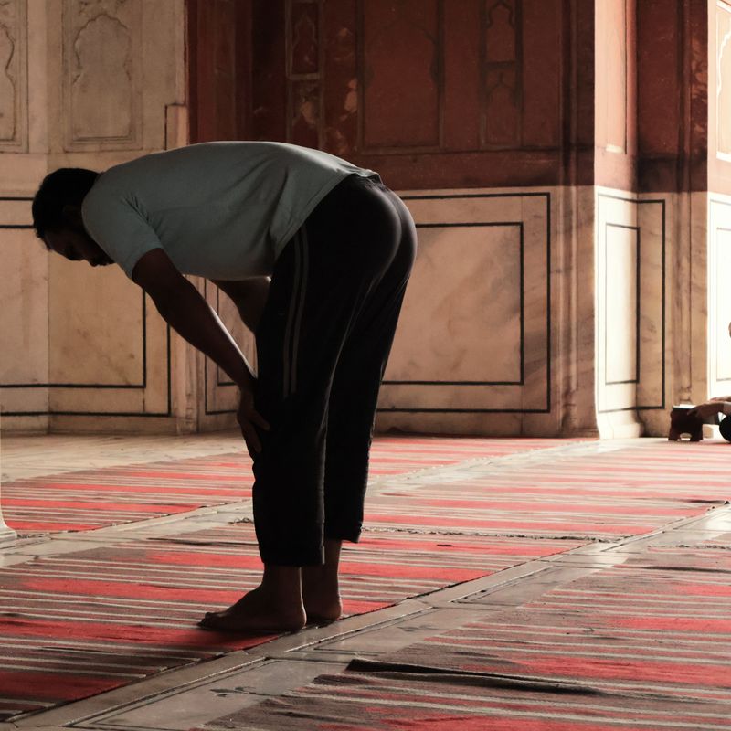 Man praying inside a grand mosque hall